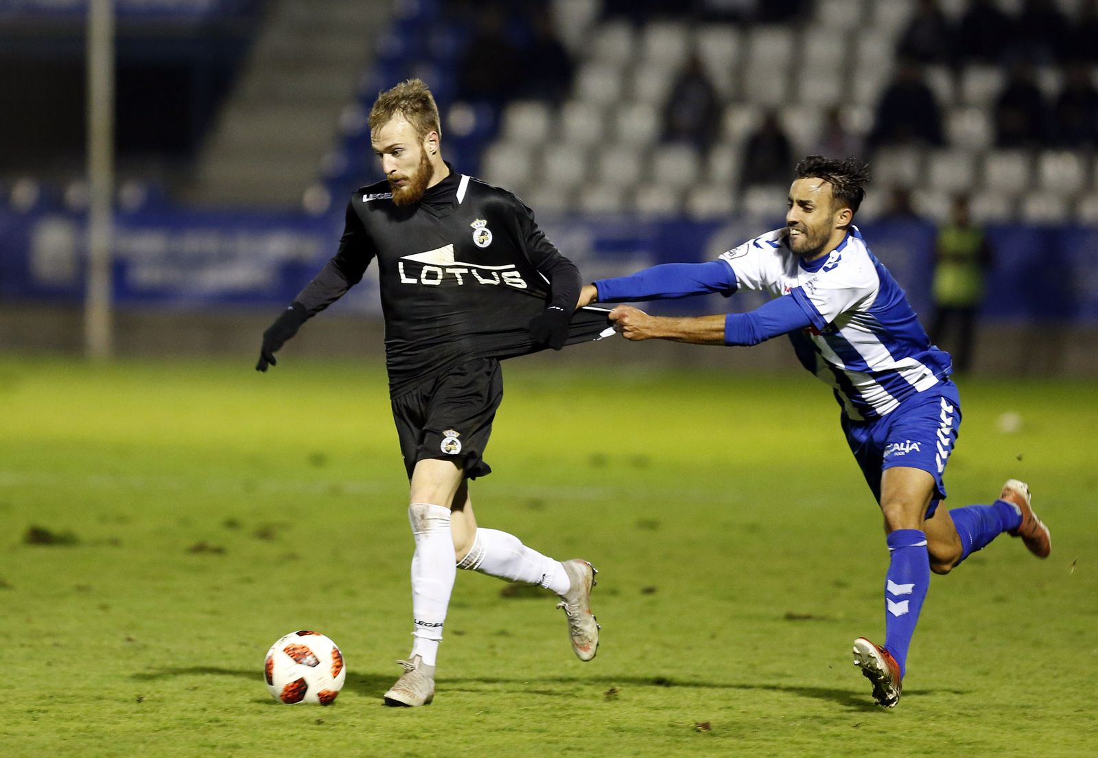 El albinegro Pierre, agarrado por el exbalono Óscar Martín, en el partido de la primera vuelta.