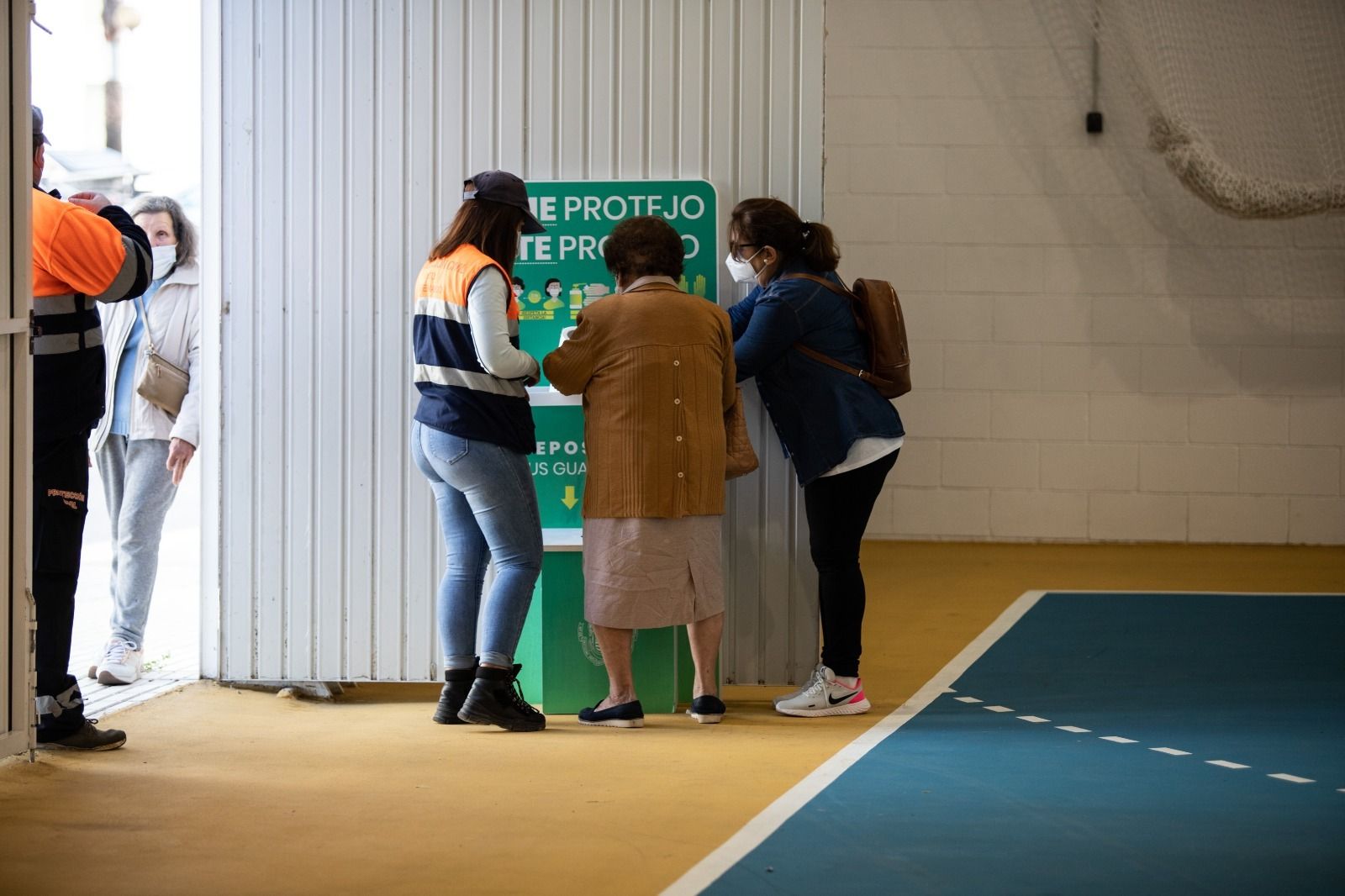Una mujer usa el hidrogel preparado en la puerta del pabellón Enrique Márquez donde se vacuna.