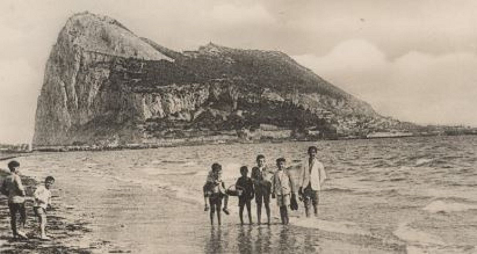Niños en la playa de La Línea y, al fondo, Gibraltar.