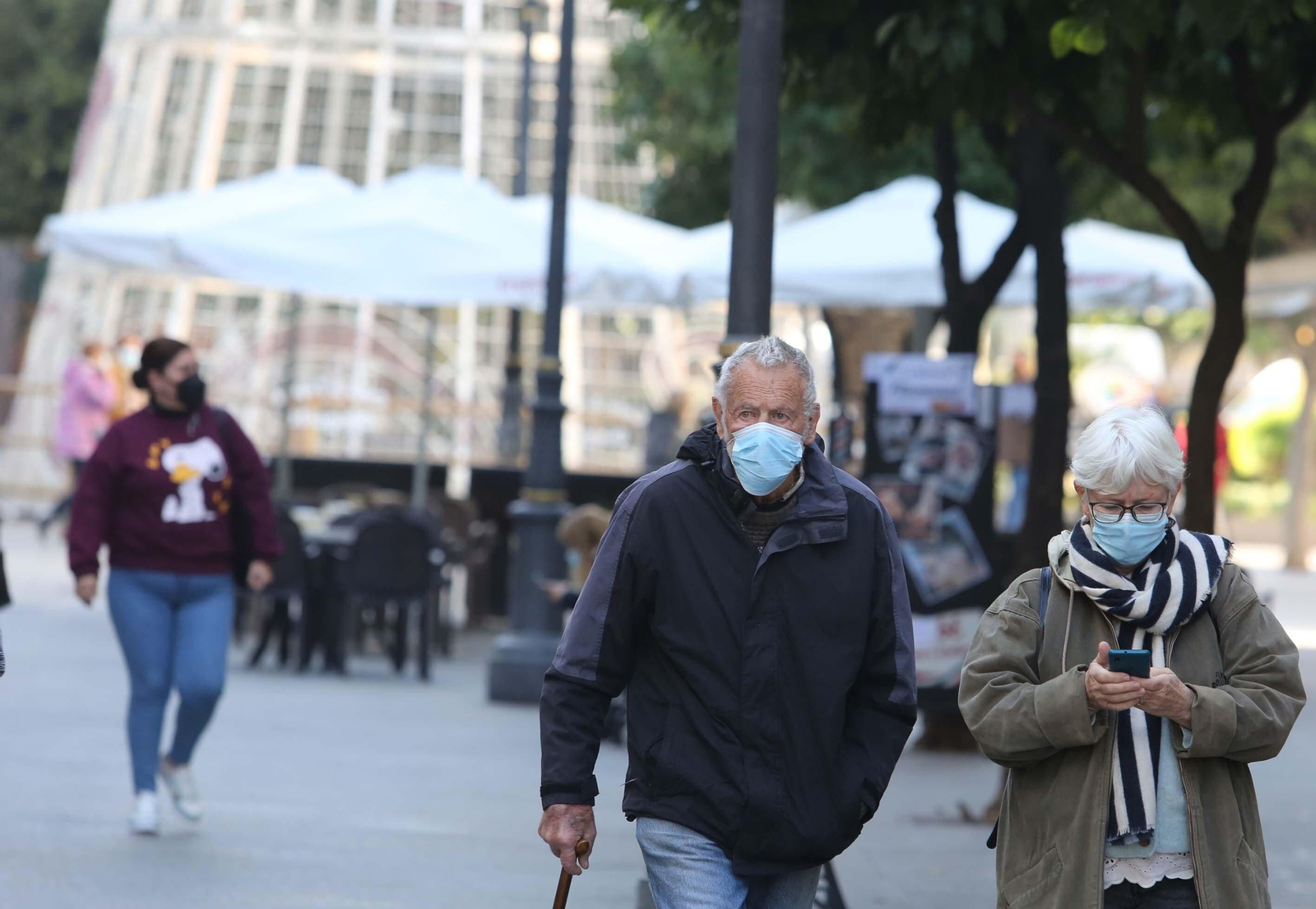 Ciudadanos pasean por el centro con la mascarilla puesta y con el árbol de Navidad del a plaza del Arenal al fondo.