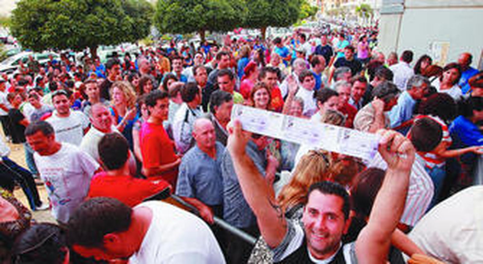 Un aficionado exhibe orgulloso sus entradas para el partido.