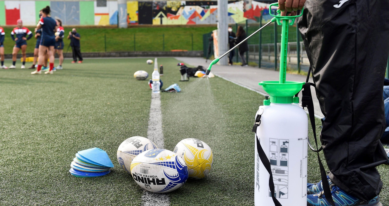 Desinfección de balones de rugby durante un entrenamiento.
