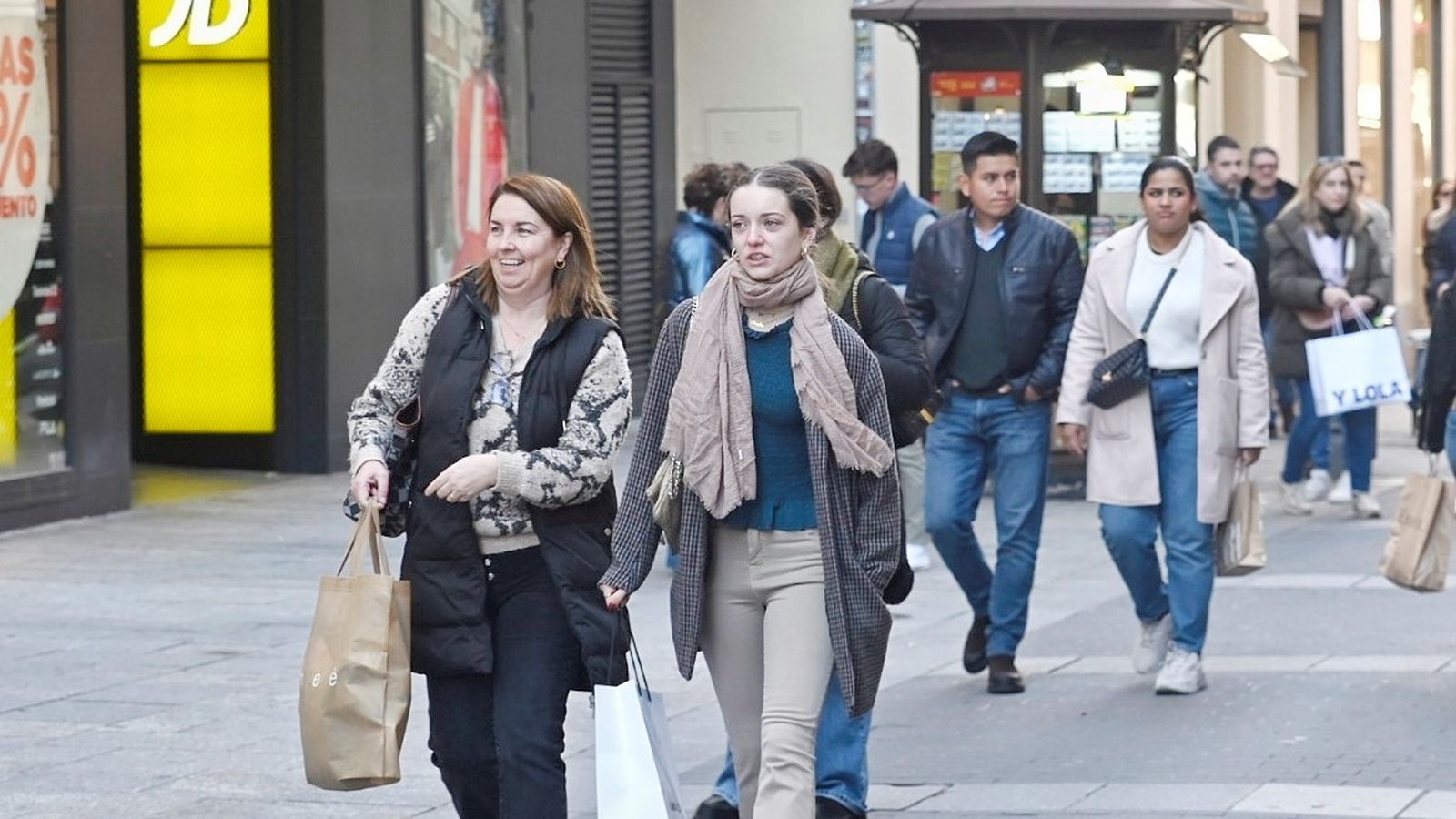 Varias personas caminan en Córdoba tras realizar compras.