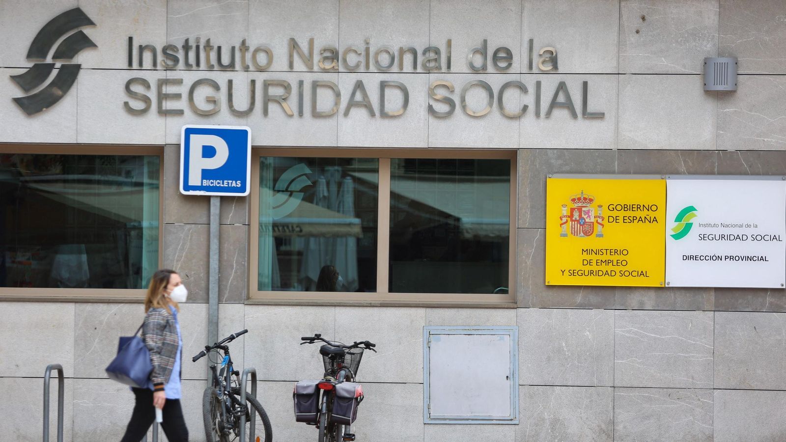 Una mujer pasa delante de una oficina de la Seguridad Social. Una mujer pasa delante de una oficina de la Seguridad Social.