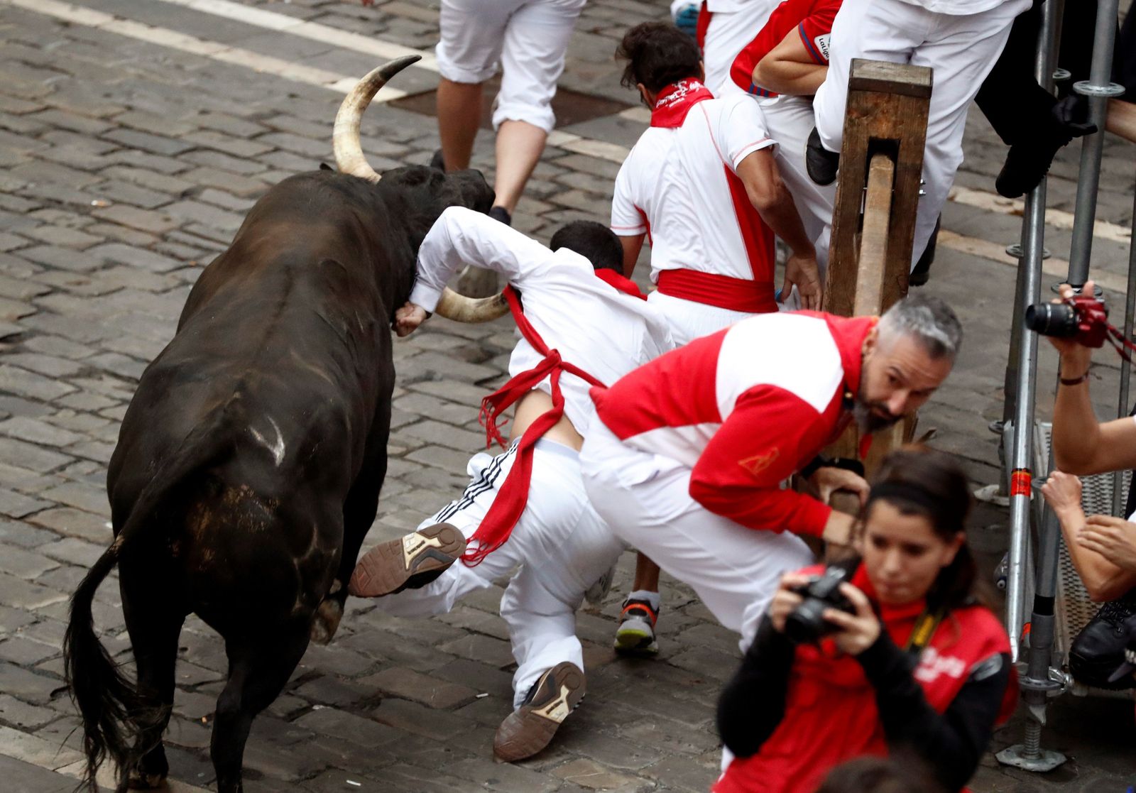 Un toro cornea a un mozo en el tramo de la Plaza consistorial de Pamplona.