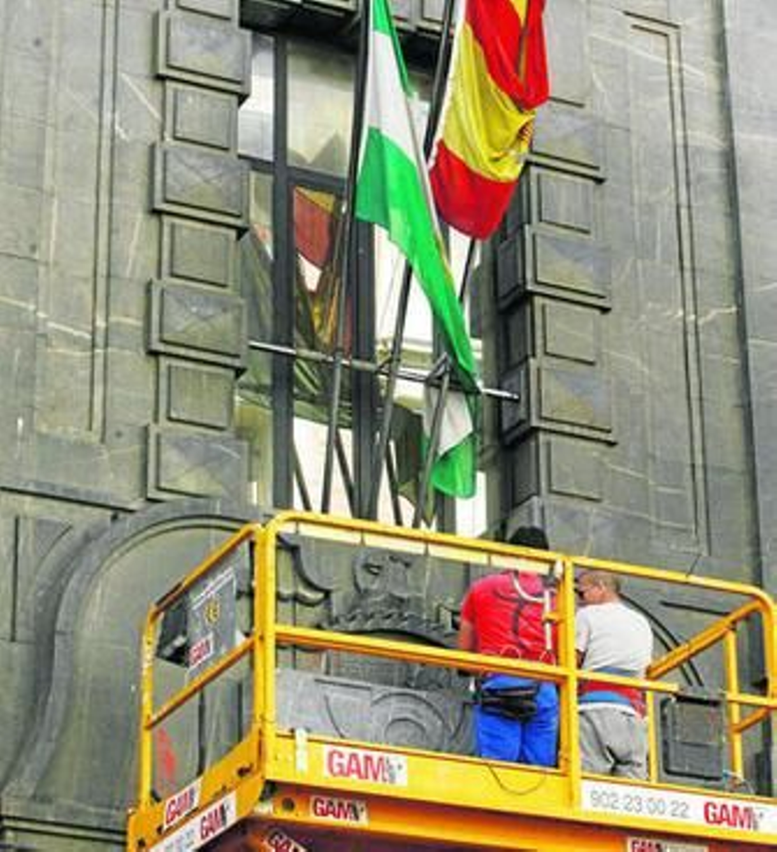 Obreros revistiendo el escudo franquista de la oficina de Correos de la calle Cruz Conde.