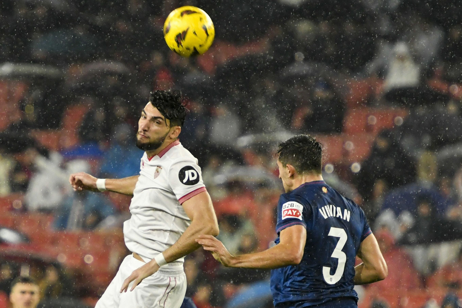 Rafa Mir golpea un balón aéreo bajo la intensa lluvia