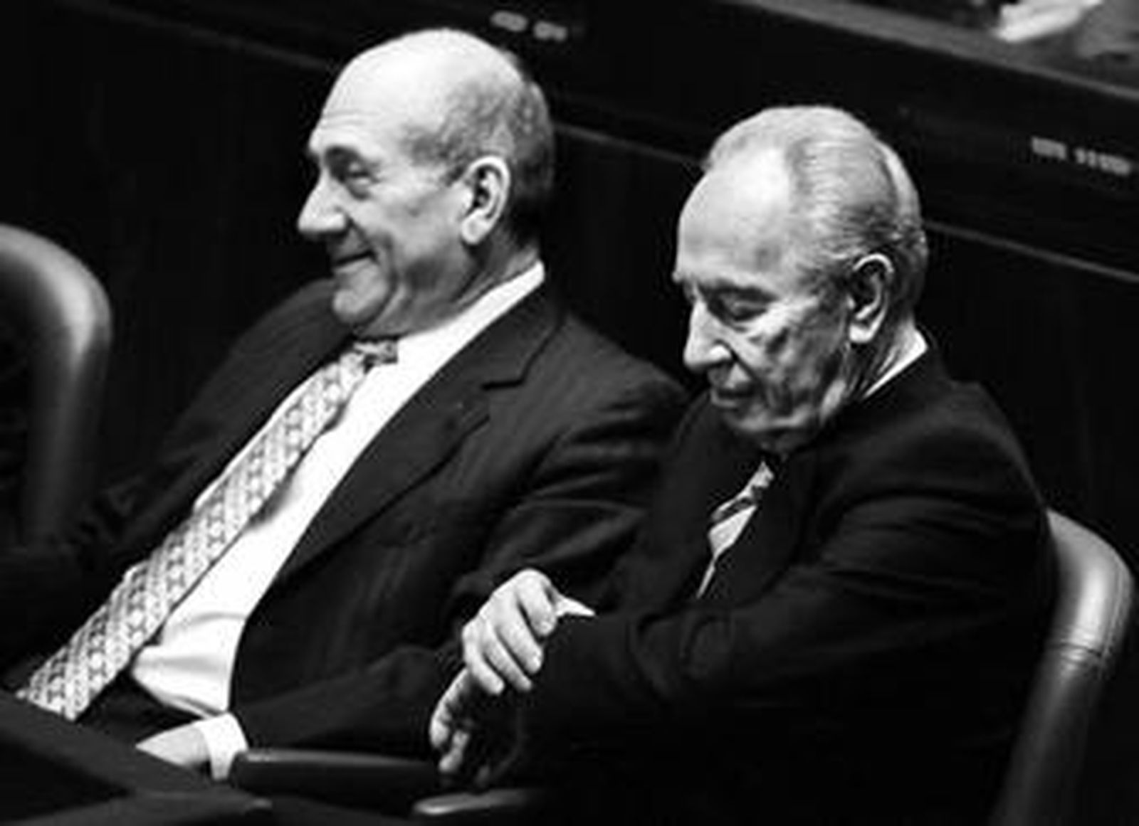 Simon Peres mira el reloj junto a Ehud Olmert (izq.) en el Parlamento israelí.