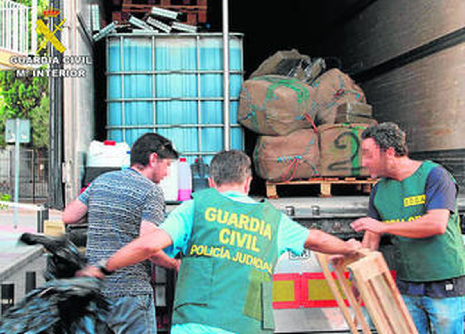 Agentes de Policía Judicial descargan el hachís intervenido en la operación.