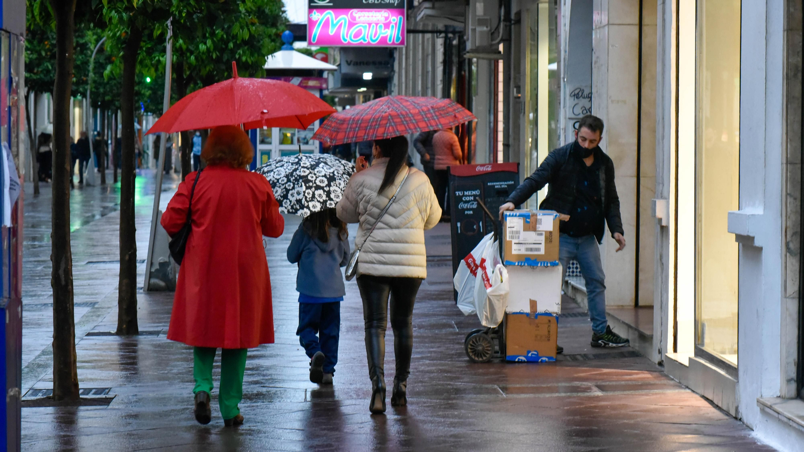 Varias personas con paraguas, en la calle Ancha de Algeciras.