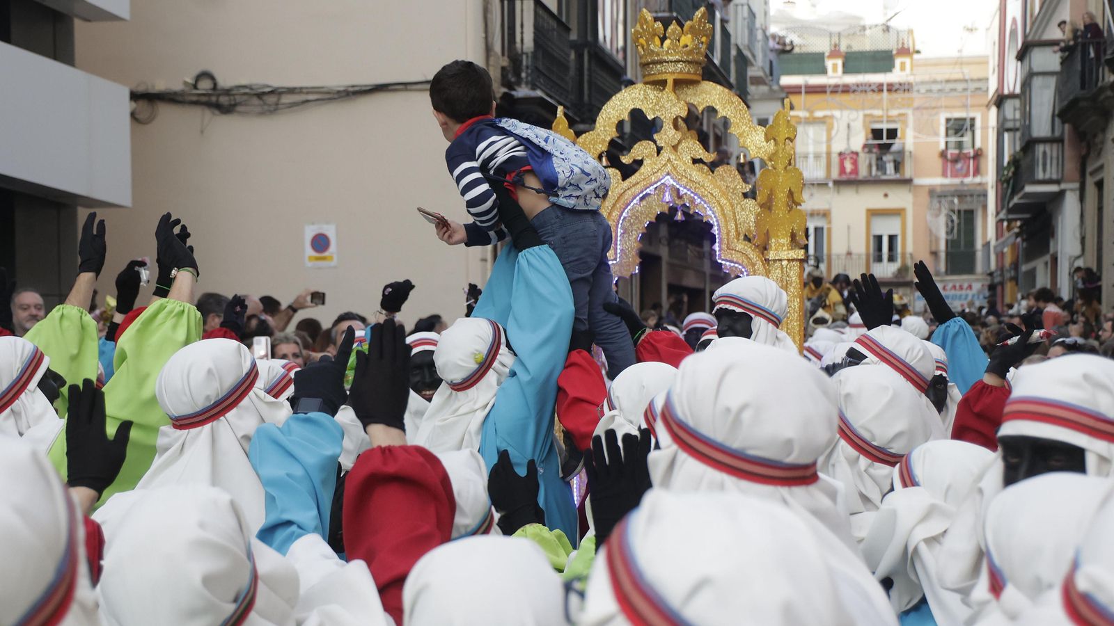 Un beduino ayuda a un niño para que eche la carta en el palanquín