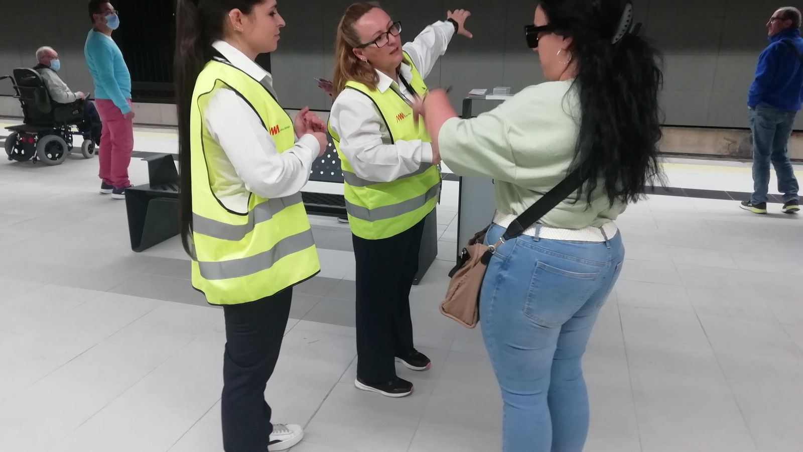 Rocío Sureda y Fátima Molero (izquierda), empleadas del Metro, informan a una usuaria.