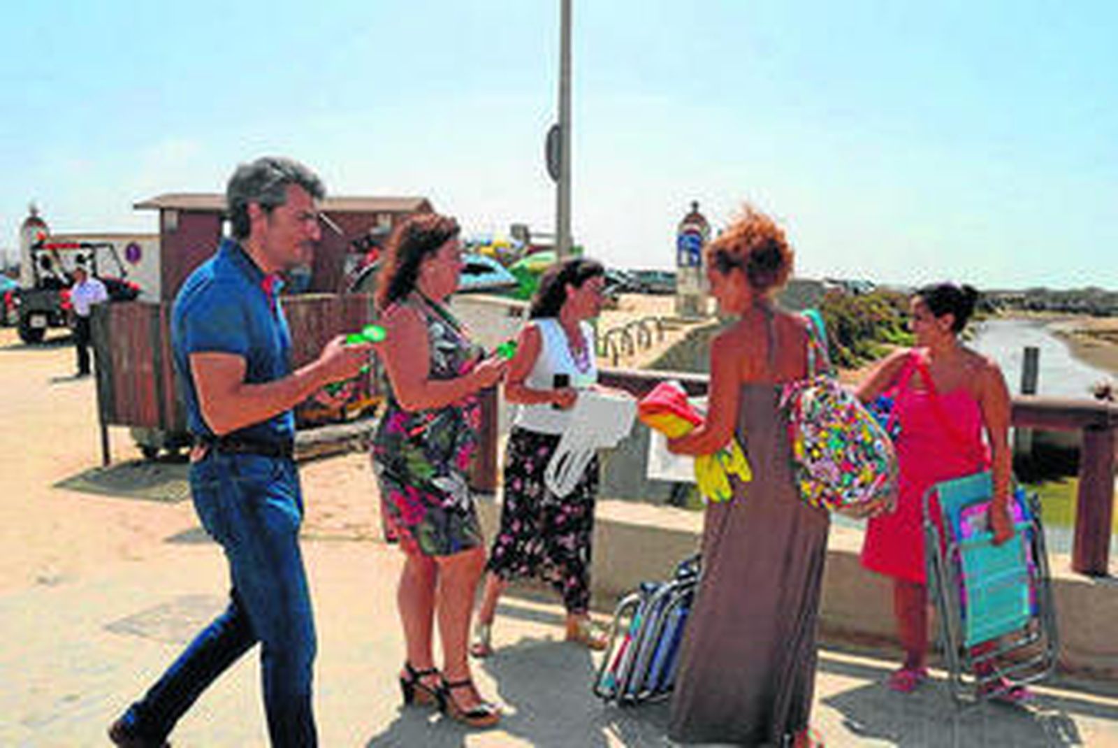 Reparto de ceniceros y bolsas en el acceso de la playa, ayer.