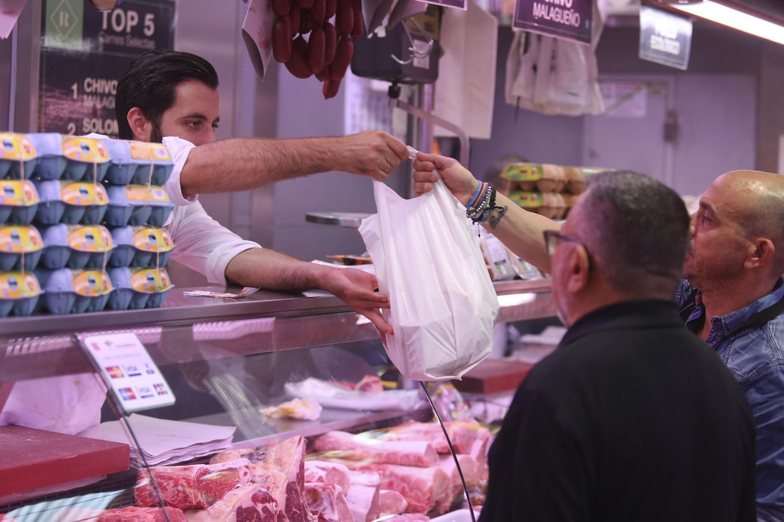 Dos hombres compran género en un puesto de carnicería del mercado de Atarazanas. Dos hombres compran género en un puesto de carnicería del mercado de Atarazanas.