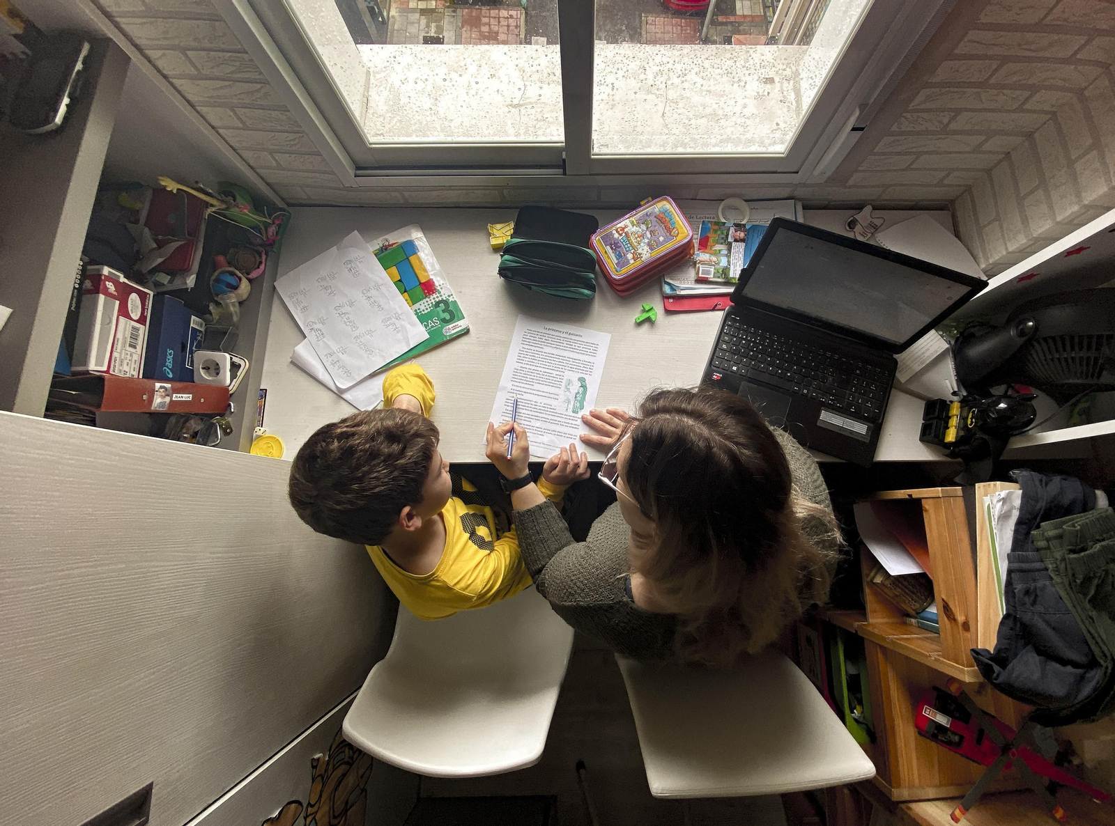 Una madre ayuda a su hijo con las tareas escolares durante el confinamiento. Una madre ayuda a su hijo con las tareas escolares durante el confinamiento.