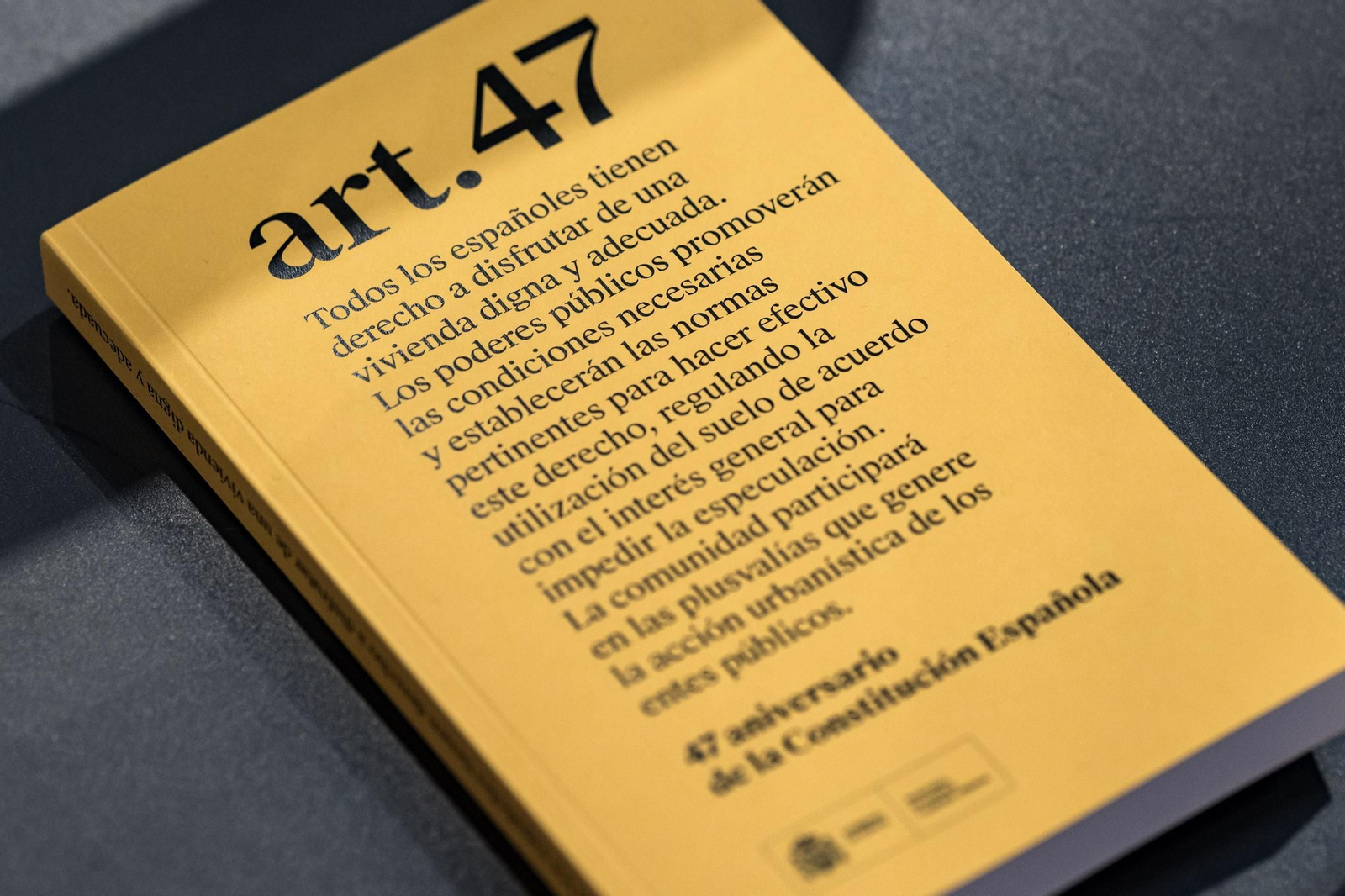 Libro con el artículo 47 de la Constitución en la portada