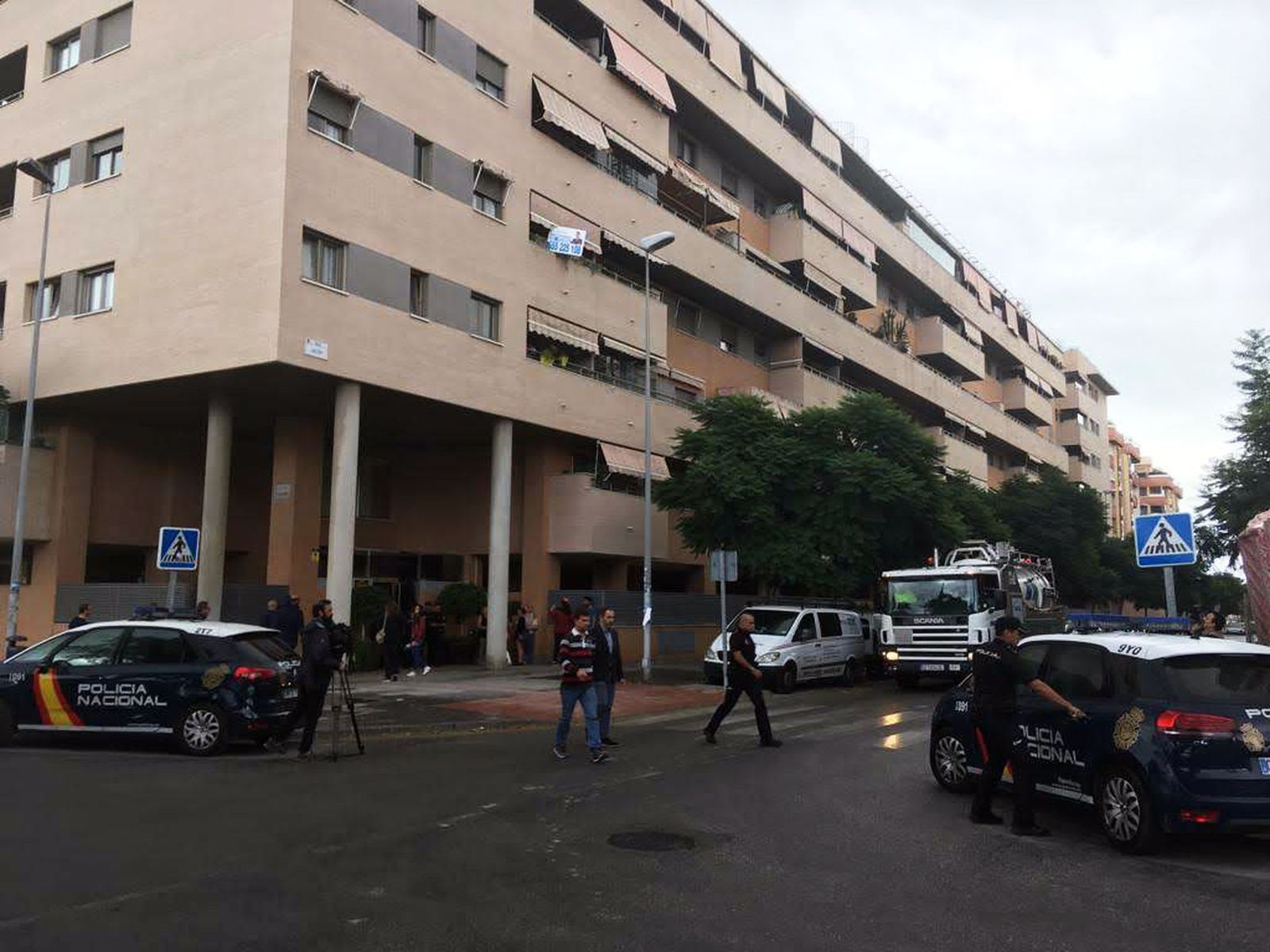 Dispositivo policial y vecinos, junto al edificio en el que ocurrieron ayer los hechos.
