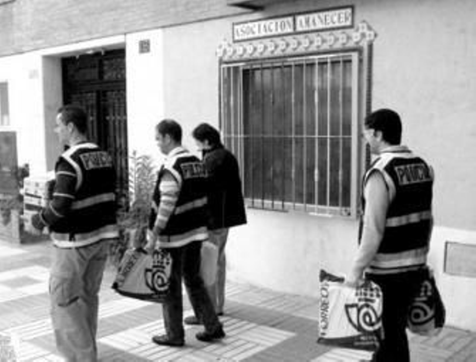 Los agentes de Policía, con la documentación intervenida en la Asociación Amanecer .