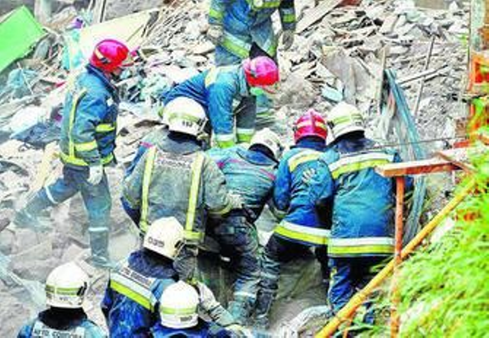 Los bomberos excarvan entre los cascotes para sacar los cuerpos.