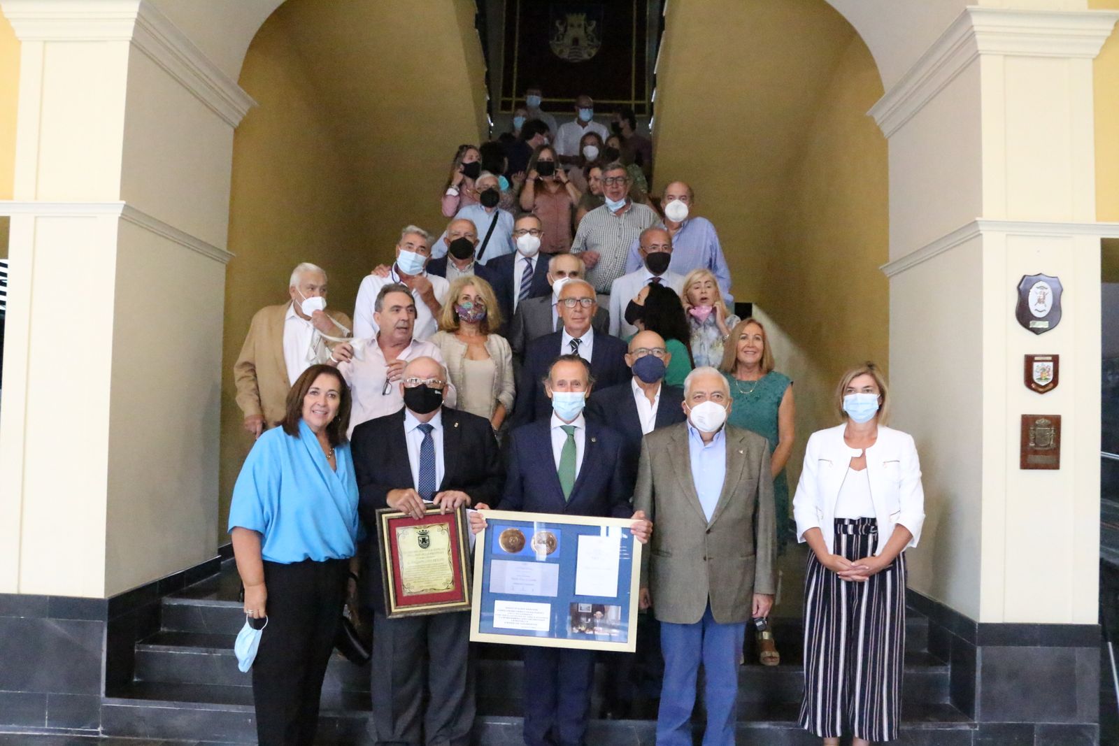 Los responsables municipales posan junto al homenajeado y sus familiares en la escalinata del Consistorio.