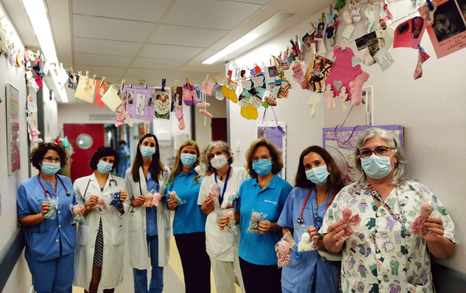 Profesionales de la Unidad de Neonatología junto a las voluntarias de Caixbank con los 'pulpos terapéuticos' donados.