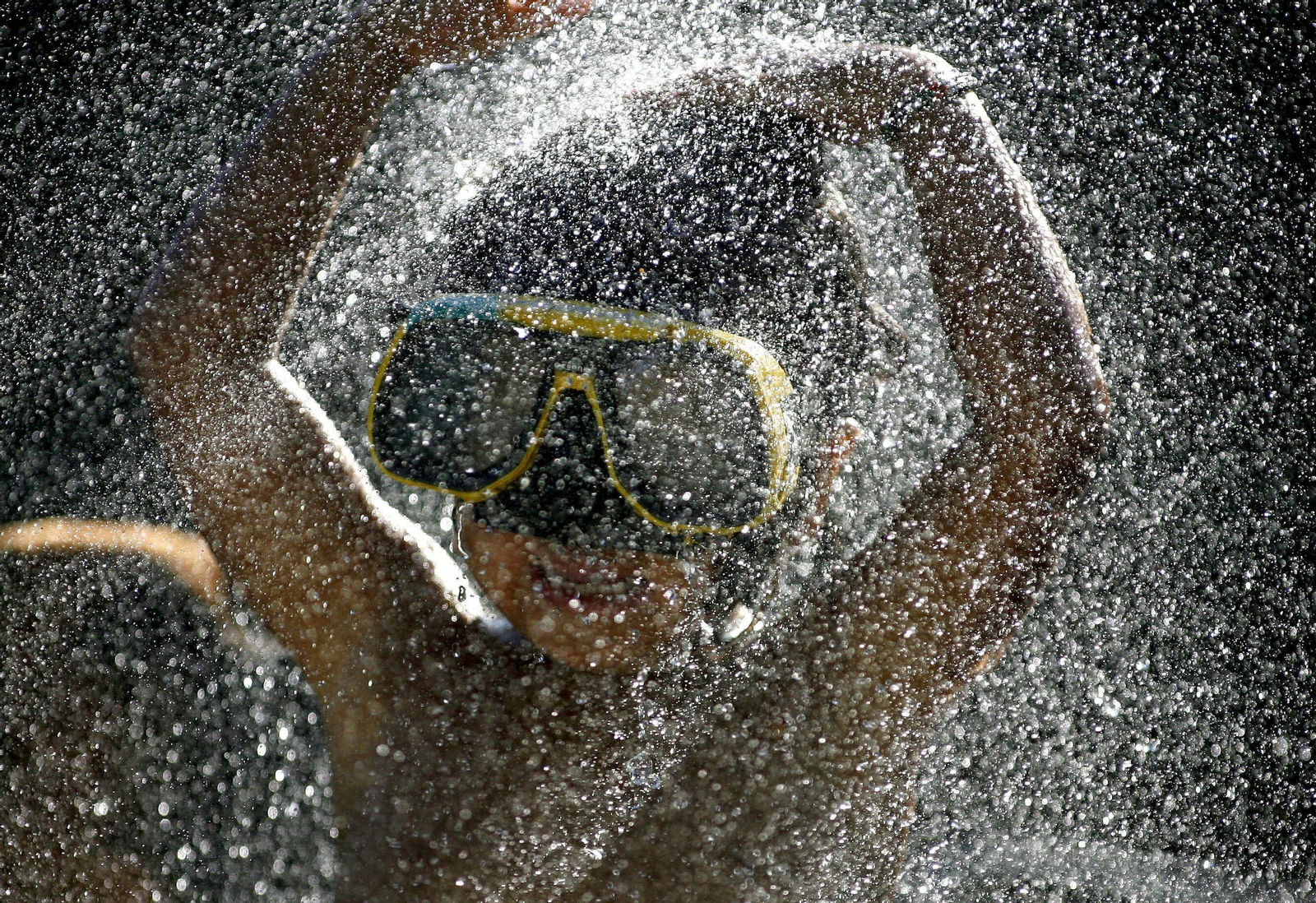 Un niño con gafas de bucear en una piscina.