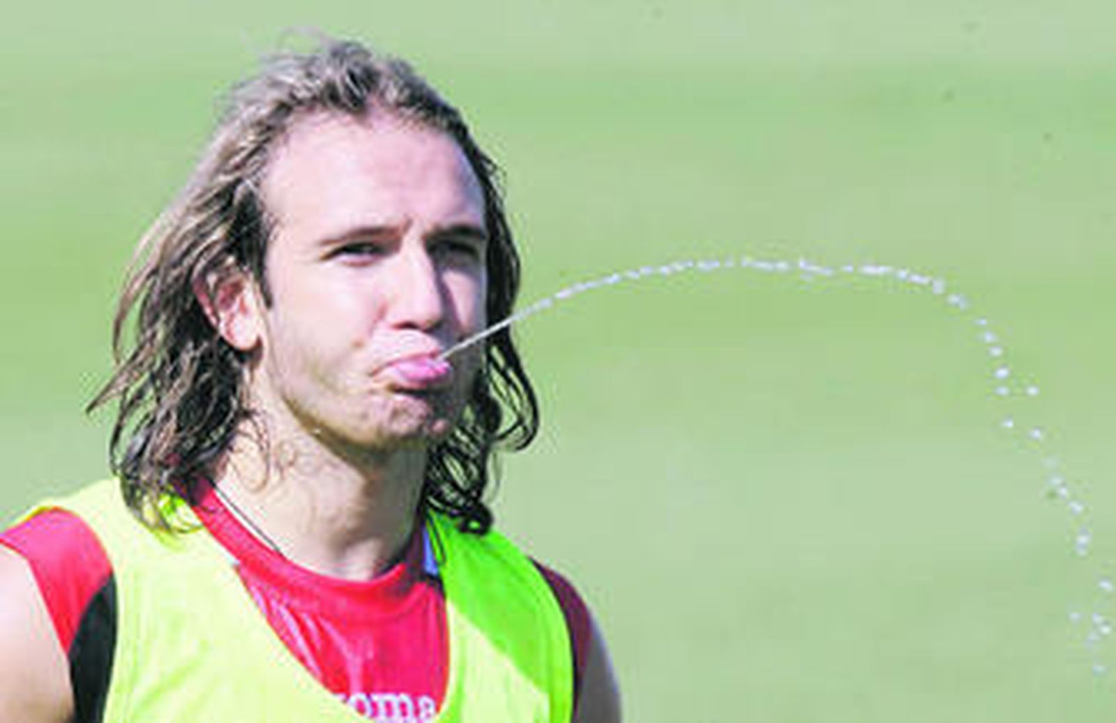 Diego Capel lanza un chorro de agua durante un receso en el entrenamiento del Sevilla.