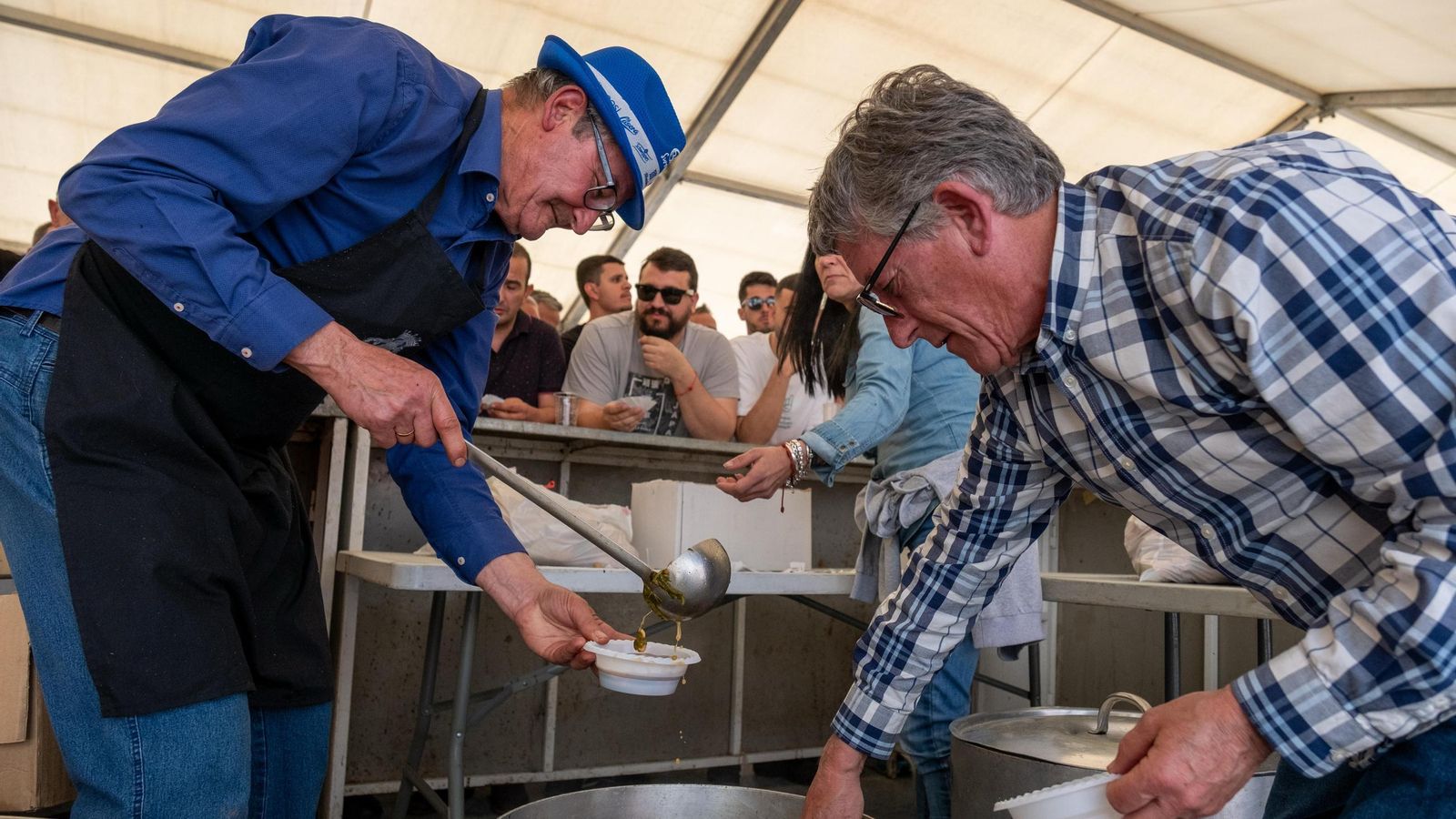 Dos personas sirviendo platos de gurumelos.