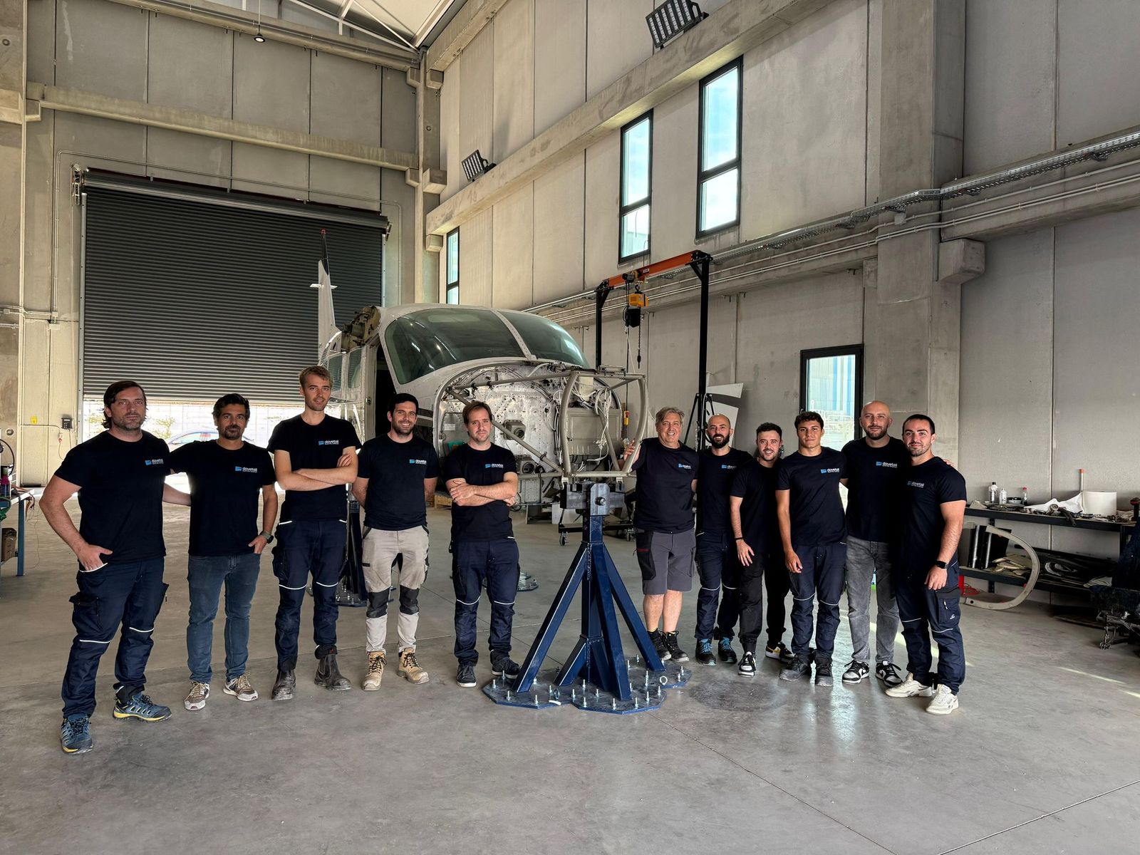 Empleados de Dovetail en el Centro de Innovación Universitario de Andalucía y, de fondo, el prototipo de CS-23 en el que trabajan