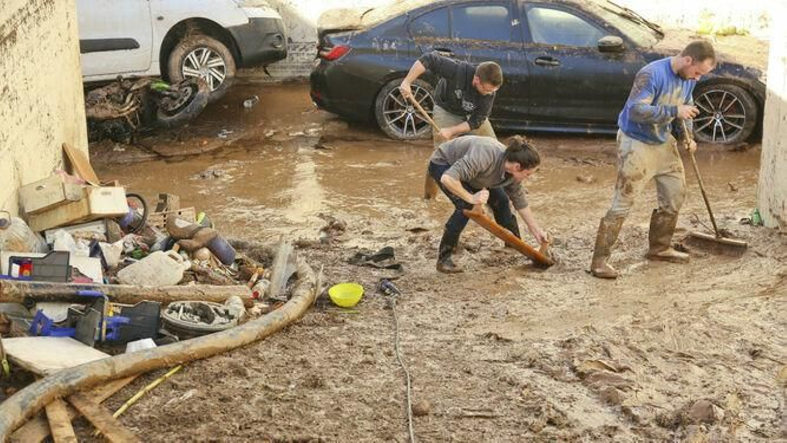 Varios vecinos retiran barro en uno de los puntos afectados. Varios vecinos retiran barro en uno de los puntos afectados.
