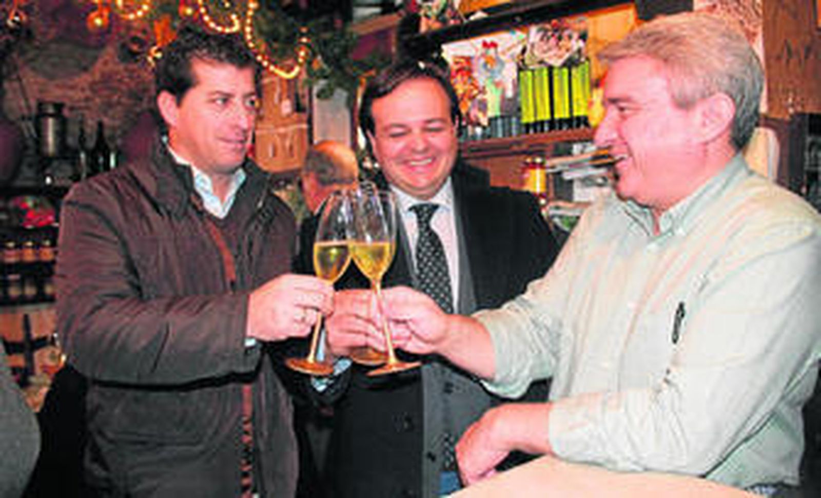 Ramón López de Tejada, a la derecha, brinda por el vigésimo aniversario de la abacería con los clientes Vicente Márquez y José Manuel Barat.