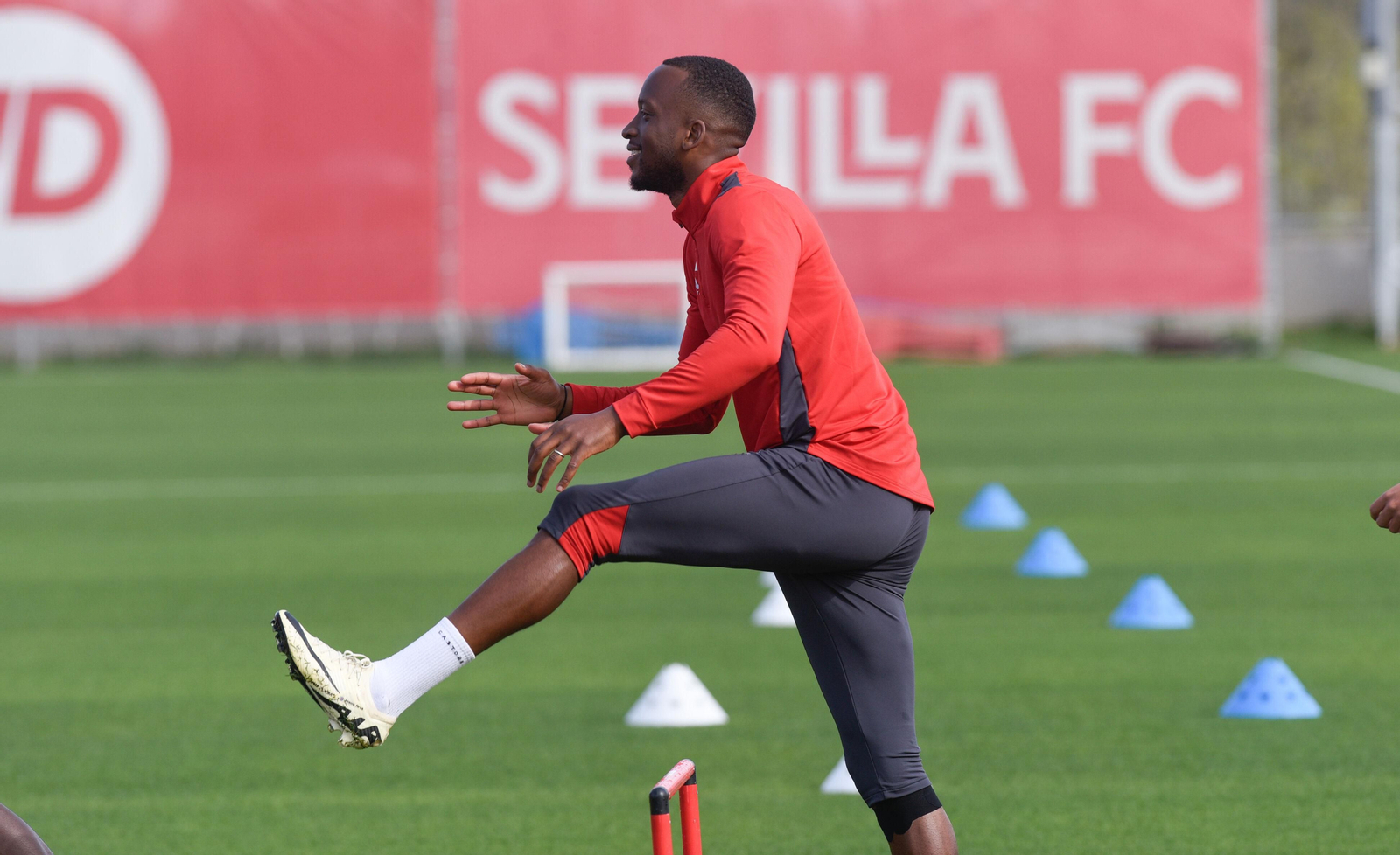 Lukébakio sonríe mientras realiza estiramientos en la ciudad deportiva del Sevilla.