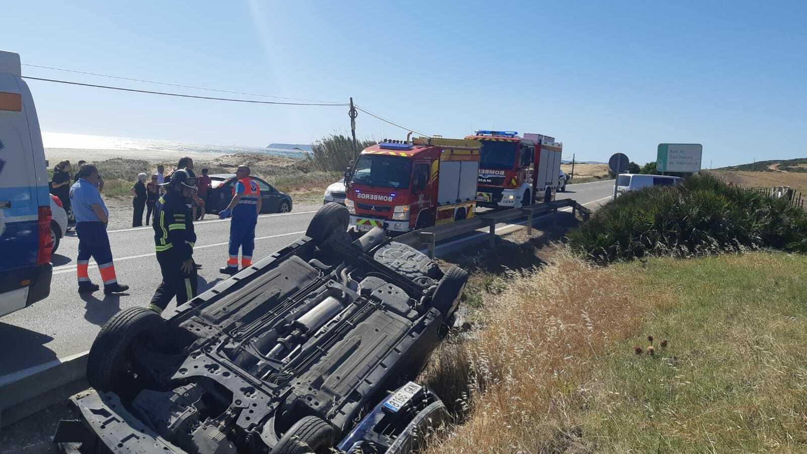 Los servicios de emergencia junto al vehículo volcado en la cuneta.
