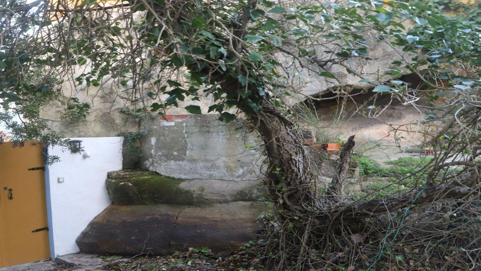 Vista del abrigo junto a una de las cuatro casas que lo rodean