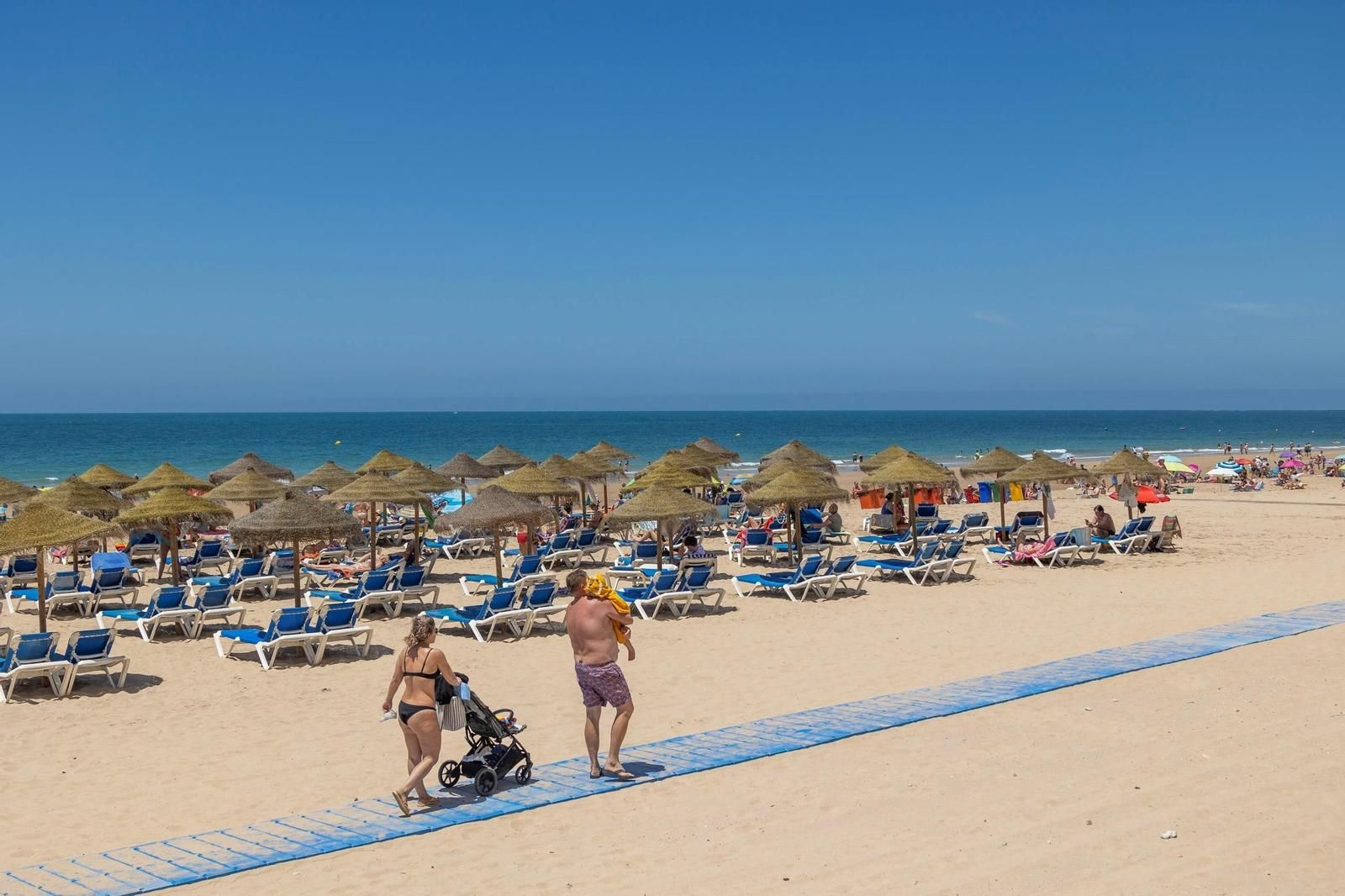 Personas llegando a la Playa de la Victoria