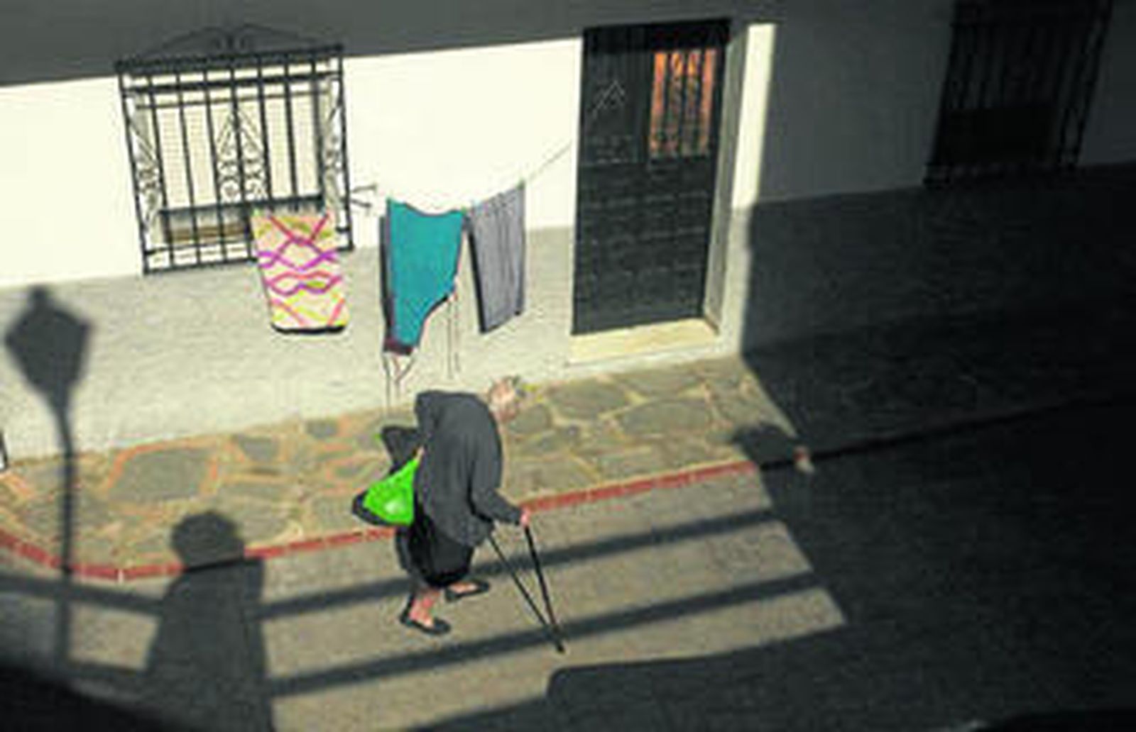 Una señora mayor se aproxima a una vivienda en la localidad de Pujerra, donde el 33% de la población tiene más de 64 años.