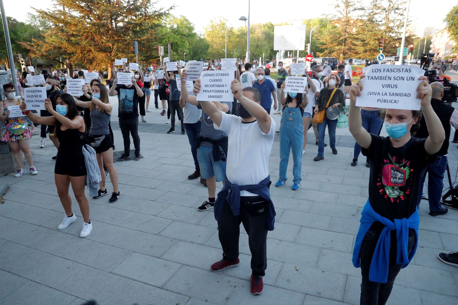 Ciudadanos con mascarillas muestran carteles durante una concentración a favor de la Sanidad pública, este jueves en Madrid.