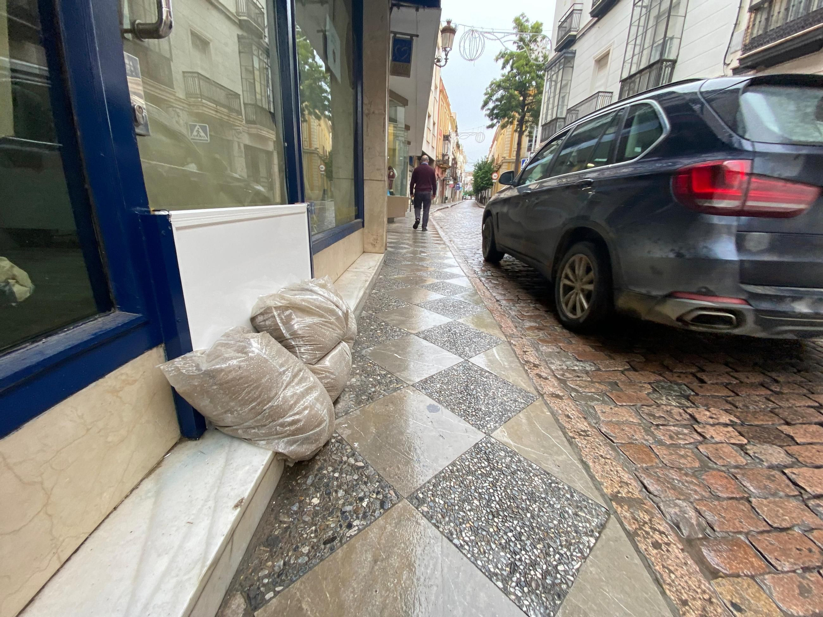 Un negocio comercial de la calle Honda protege la entrada del establecimiento con sacos de arena