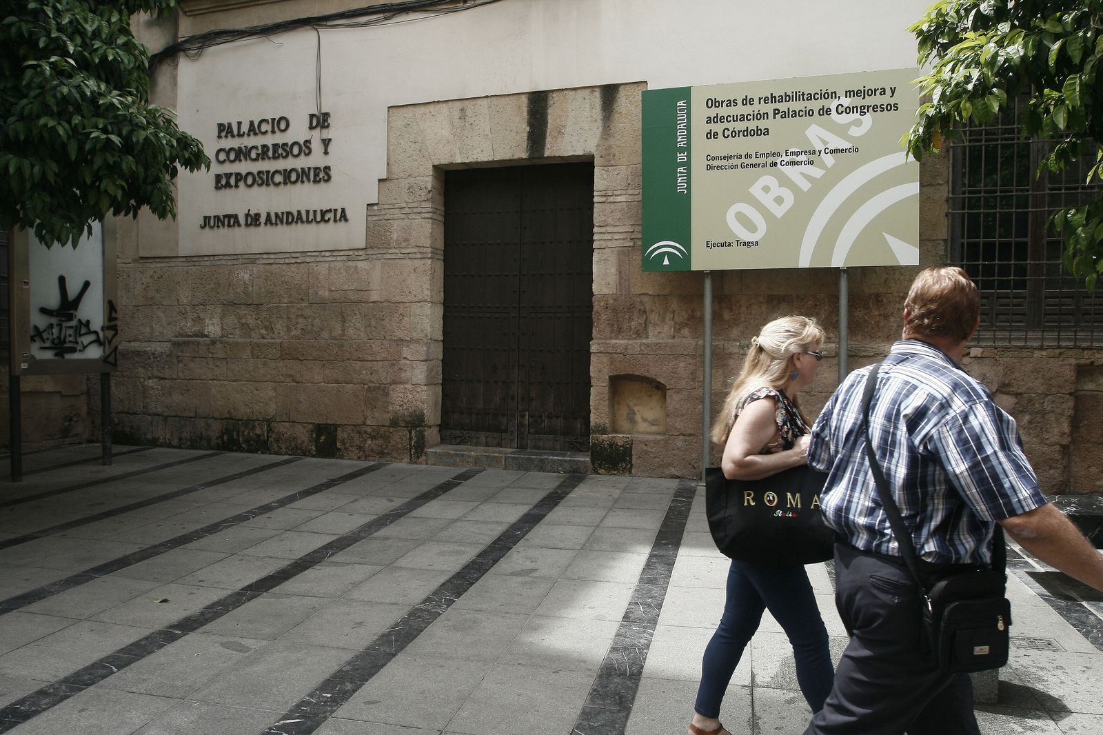 Una pareja pasa por la puerta del palacio de congresos, cerrado por obras.