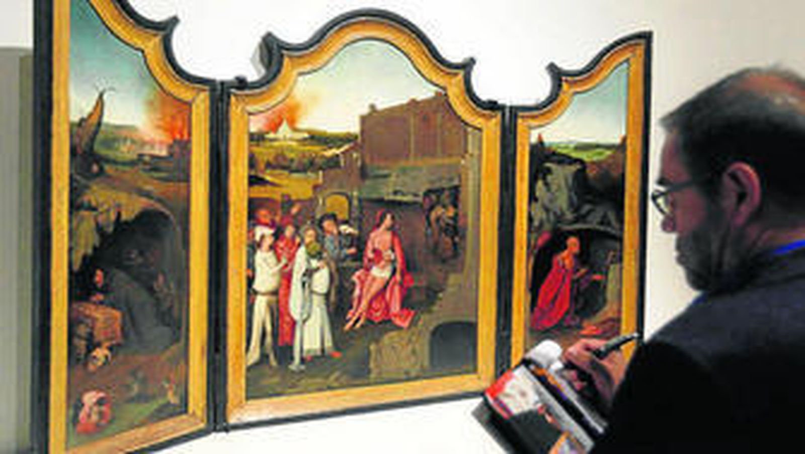 Un visitante de la exposición ante el 'Tríptico de Job'.