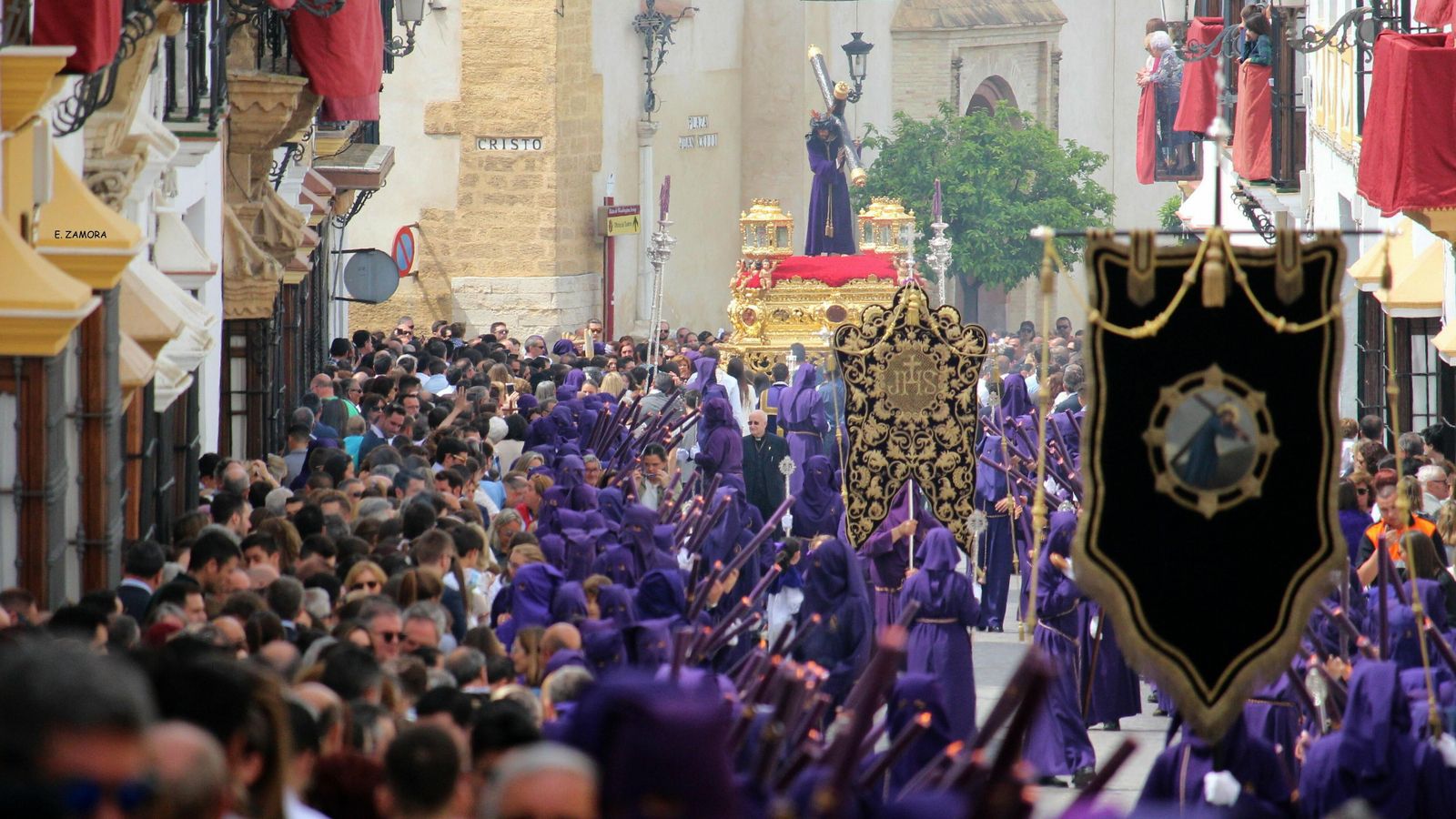 El Nazareno discurre por unas calles repletas de público. Los nazarenos no llevan cartonera.