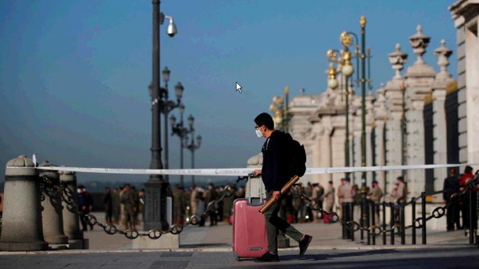 Un joven camina con una maleta por el centro de Madrid.