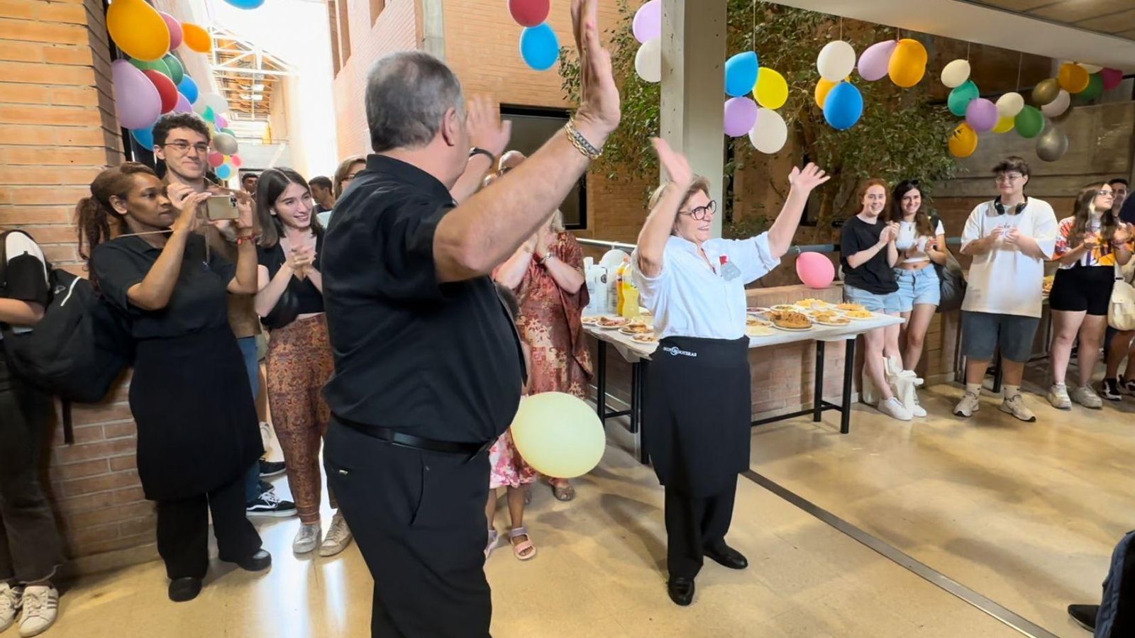 Jose y Ana se despiden de los alumnos y el personal de la universidad a las puertas del bar de la facultad