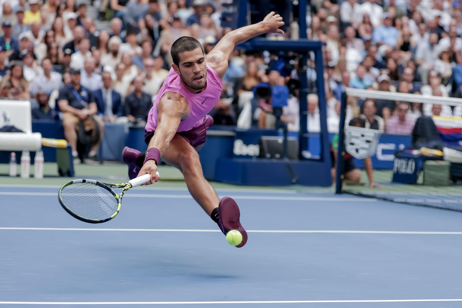 Carlos Alcaraz, en una complicada bola ante Novak Djokovic.