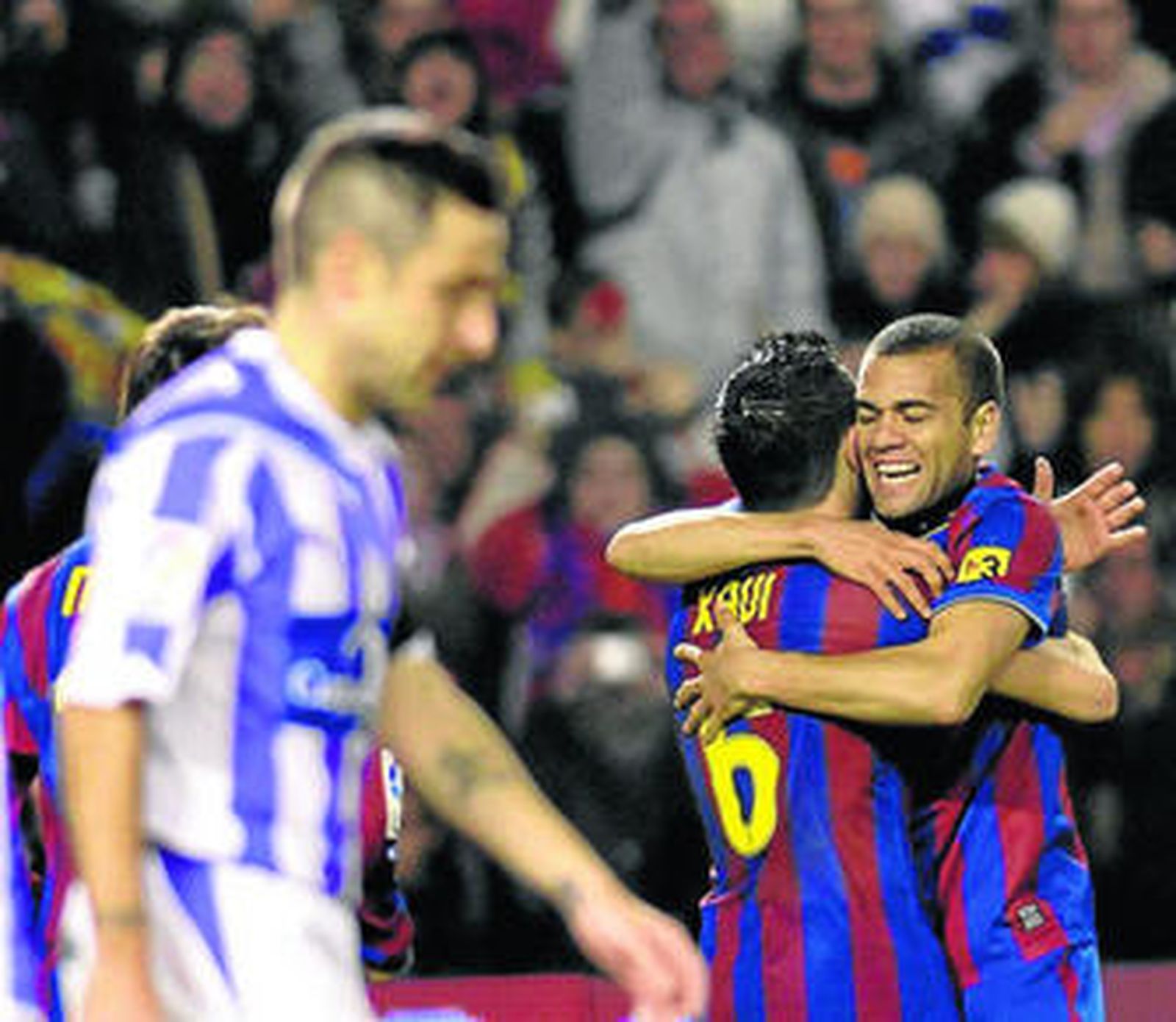 Daniel Alves celebra su gol logrado ante el Valladolid junto a Xavi.