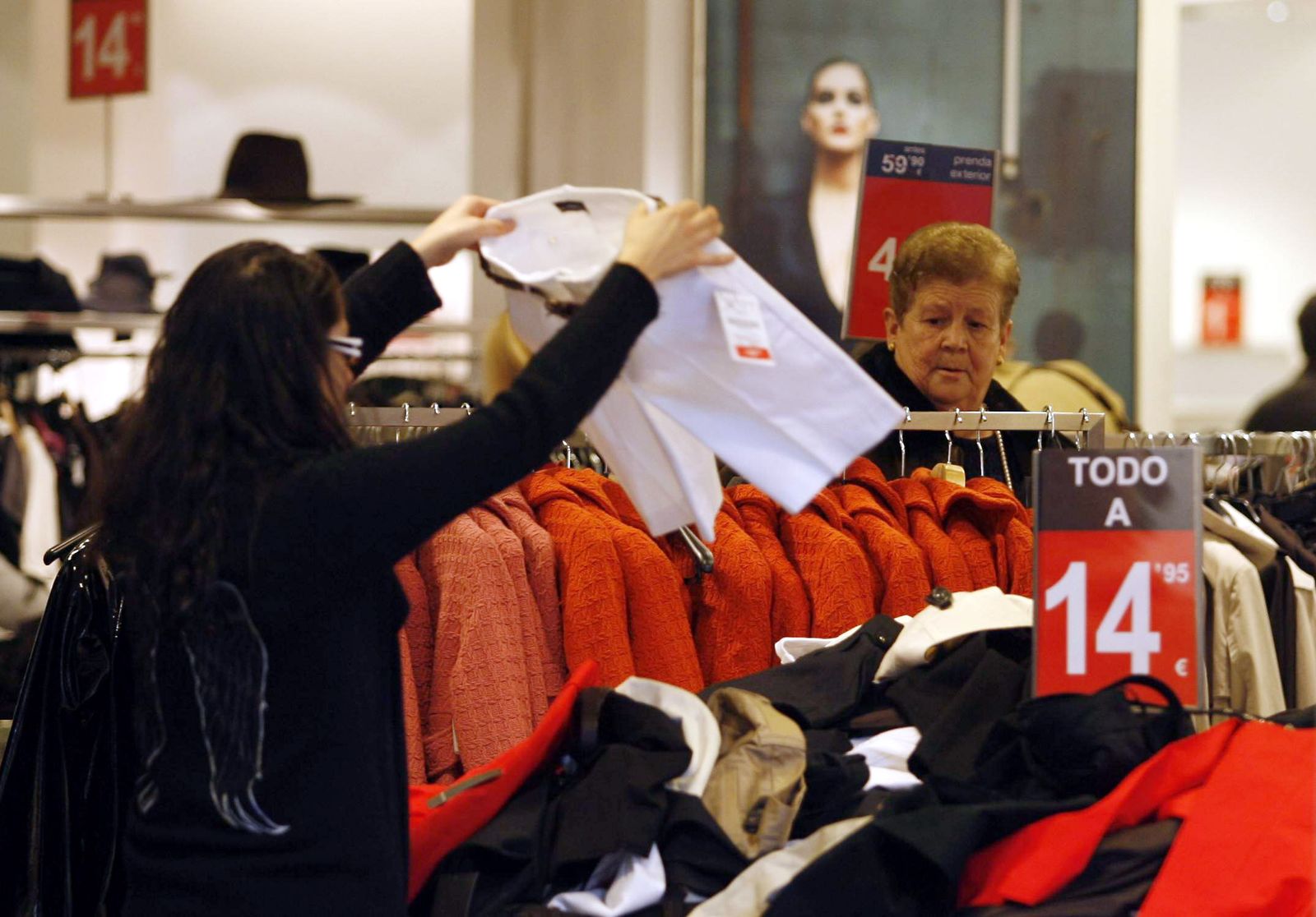 Varias personas de compras en el interior de un establecimiento.