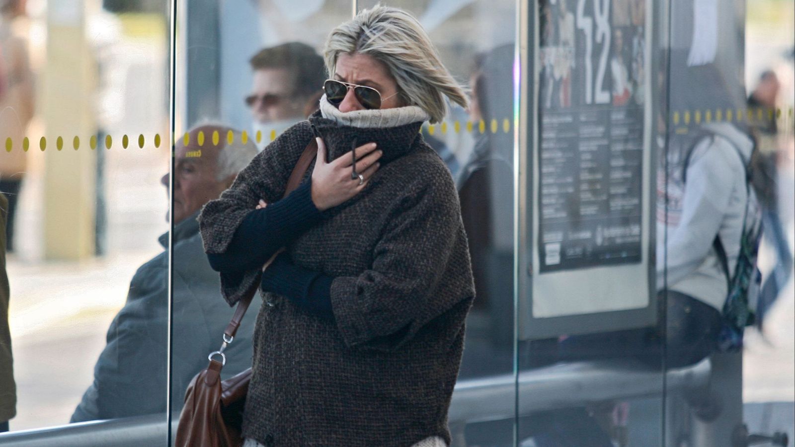 Una mujer se tapa parte del rostro por el frío | Imagen de archivo