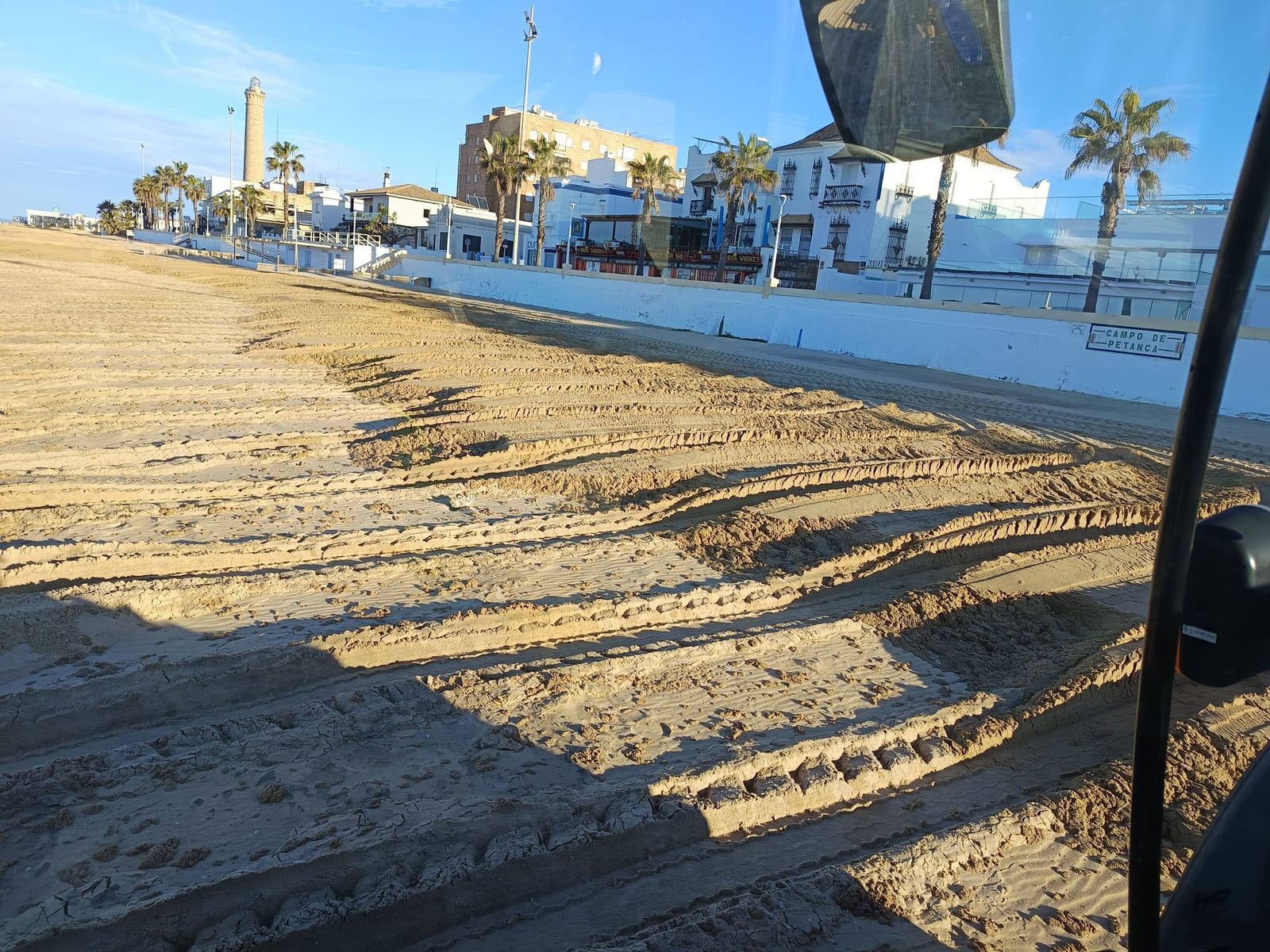 Trabajos de acopio de arena en la playa de Regla de Chipiona.