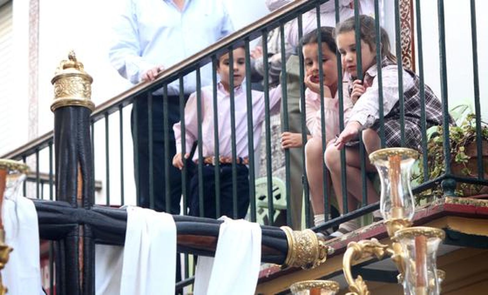 Una niña intenta tocar desde un balcón la cruz del paso de Nuestra Señora de Las Angustias.

Foto: vanesa lobo
