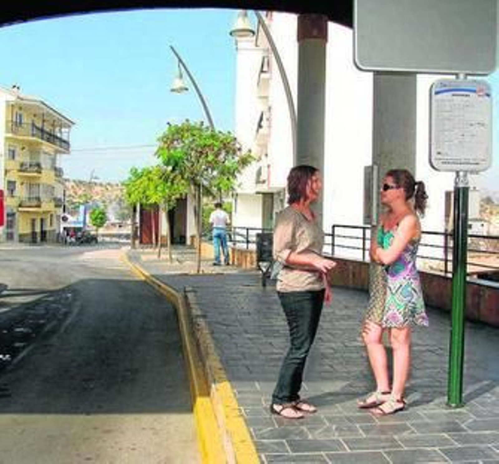 Dos mujeres esperan en una de las paradas de autobús de Coín.